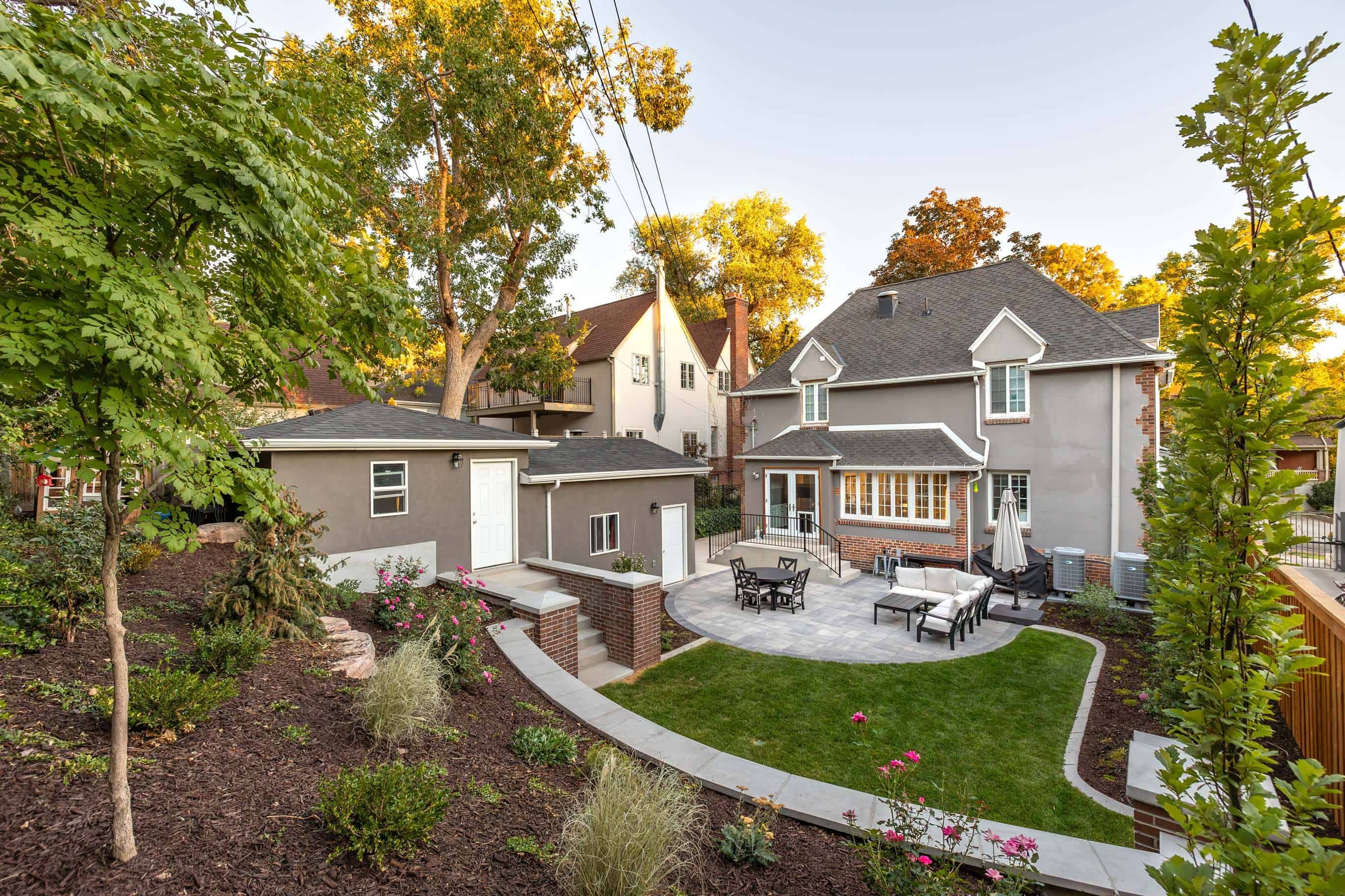 Custom landscape design with retaining wall, pavers, concrete steps, and metal railings in Federal Heights, Salt Lake City.